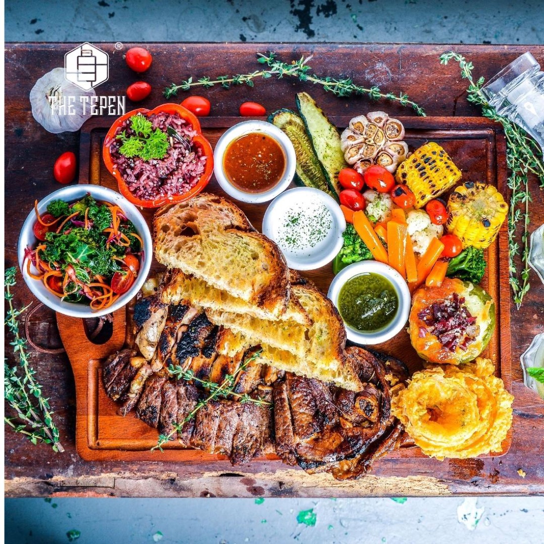 A sharing board of grilled meats, sourdough and house condiments at The Tepen